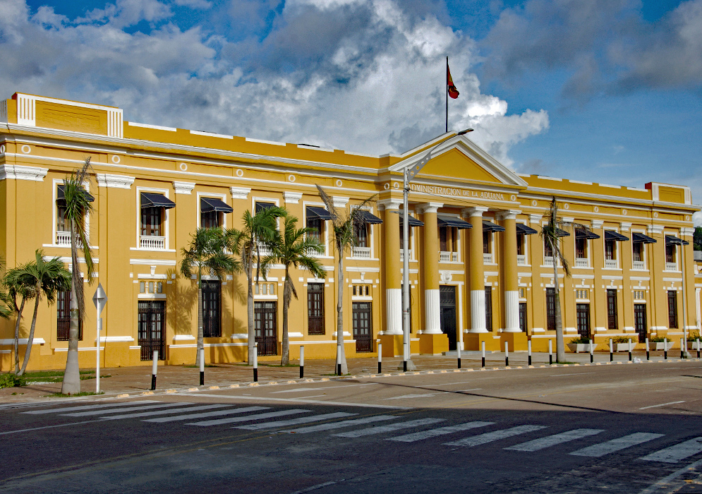 Aduana Long yellow and white building under blue skies