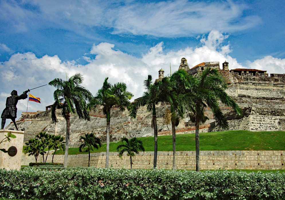 The Castillo San Felipe de Barajas, a statue of a solder with a sword, the Colombian flag and palm trees