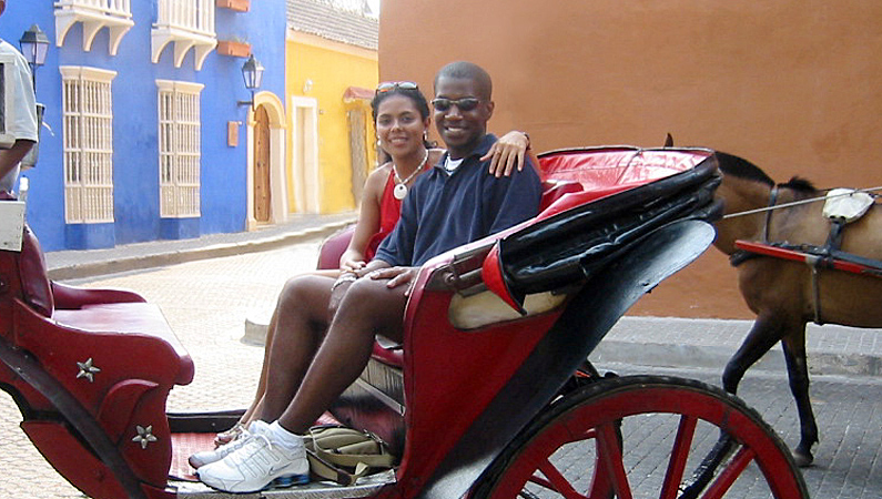 A Colombian woman and an American man riding a horse carriage on a matchmaking date in Cartagena