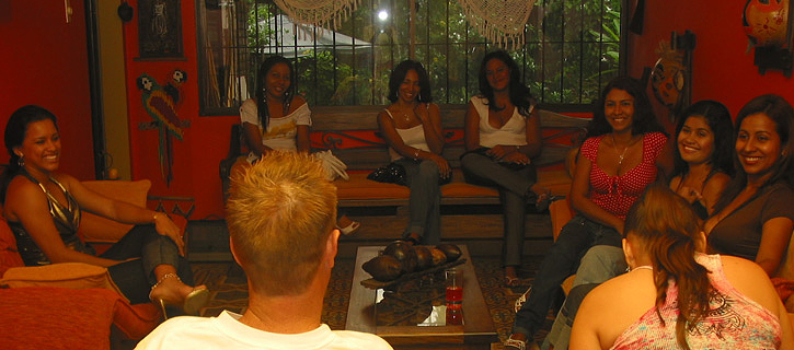 A group of Colombian women in a living room meeting a very happy man