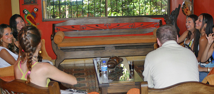 Group Introduction Meeting in Colombia American guests and Colombian women seated in a circle in a colorful room, smiling and chatting during a group introduction event