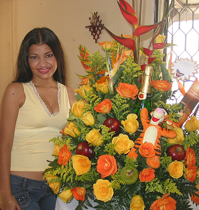 A Colombian woman receiving beautiful flowers, fruits, chocolate, teddy bear and wine as a gift