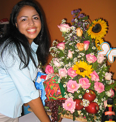 A Colombian woman receiving beautiful flowers, fruits, chocolate, teddy bear and wine as a gift