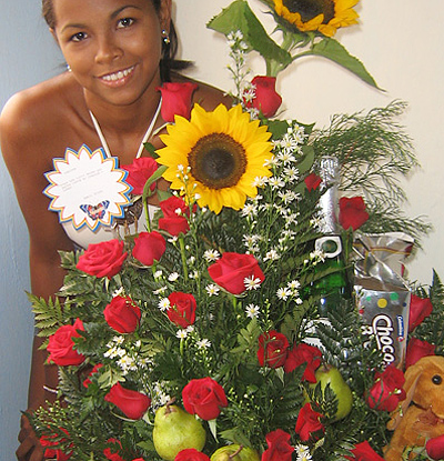 A Colombian woman receiving beautiful flowers, fruits, chocolate, teddy bear and wine as a gift