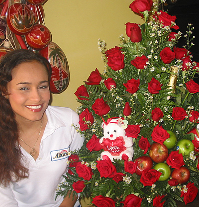 A Colombian woman receiving beautiful flowers, fruits, chocolate, teddy bear and wine as a gift