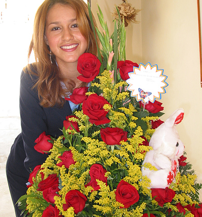 A Colombian woman receiving beautiful flowers, fruits, chocolate, teddy bear and wine as a gift