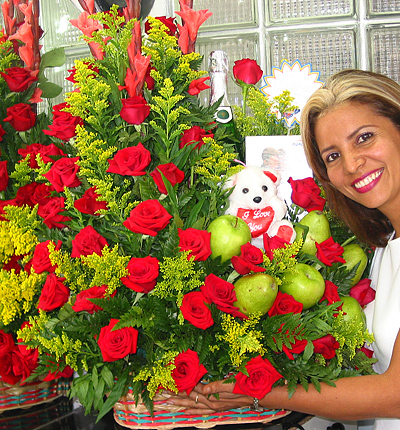 A Colombian woman receiving beautiful flowers, fruits, chocolate, teddy bear and wine as a gift