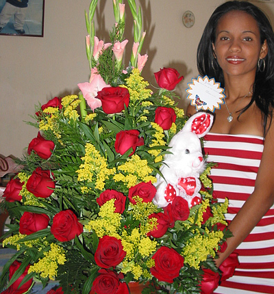 A Colombian woman receiving beautiful flowers, fruits, chocolate, teddy bear and wine as a gift