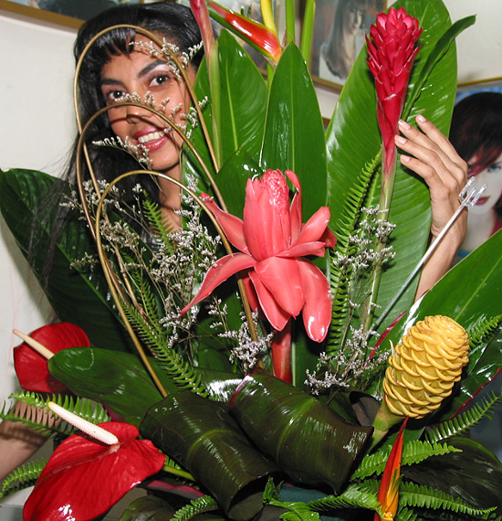 A Colombian woman receiving beautiful flowers, fruits, chocolate, teddy bear and wine as a gift