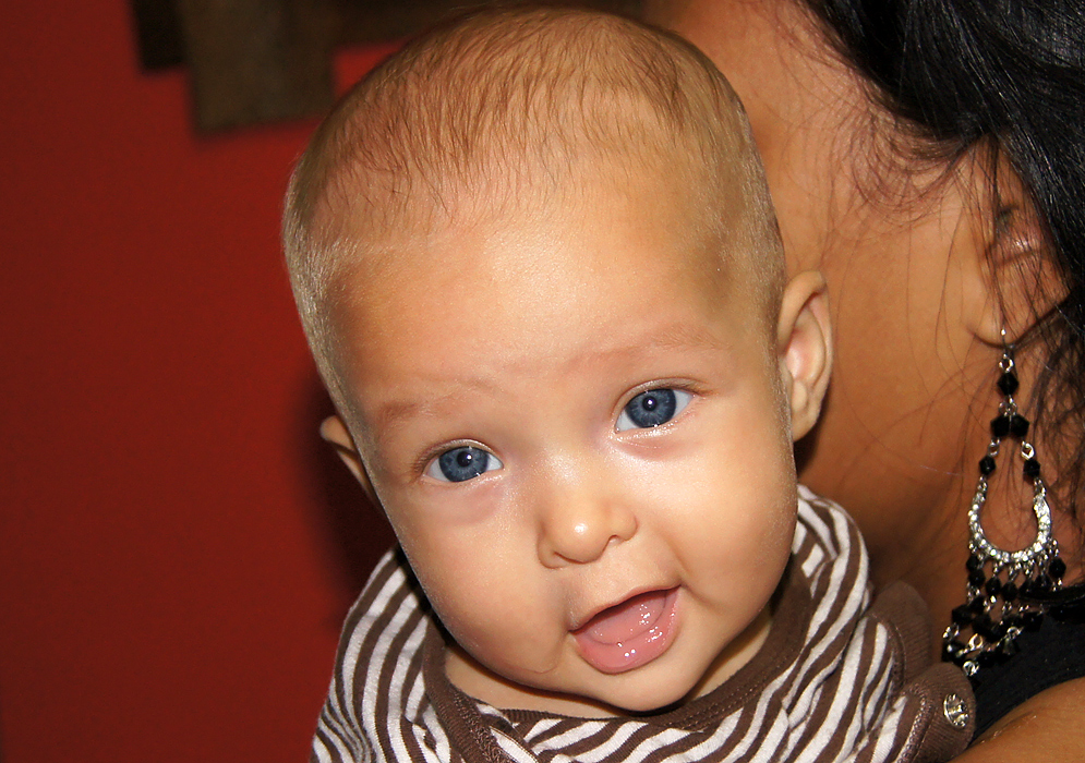 Three month old American Colombian baby with blue eyes and new smile