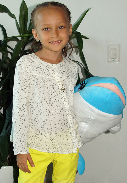 A little girl holding her new toy blue dolphen