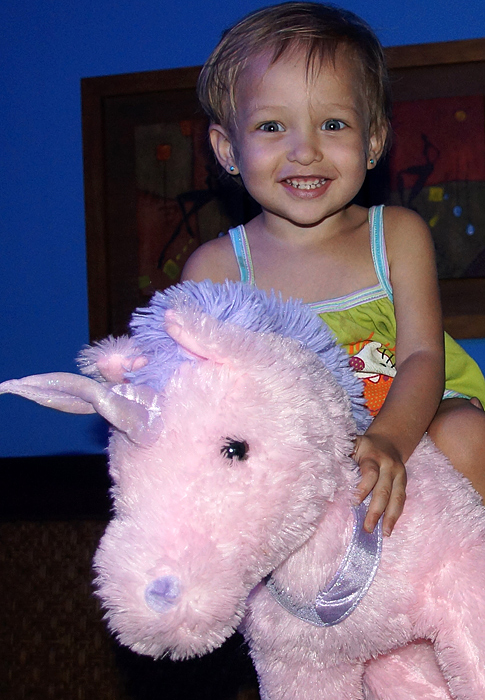 Toddler on top of a pink unicorn