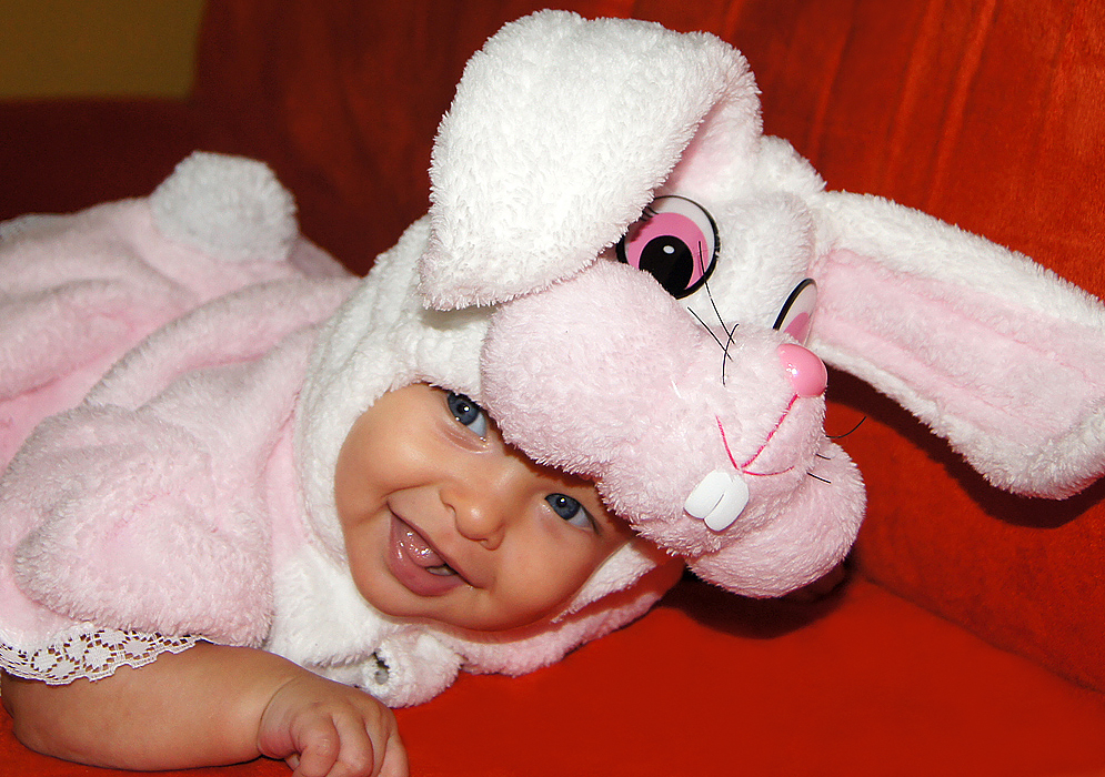 Smiling four month old American Colombian baby wearing her pink rabbit Halloween costume