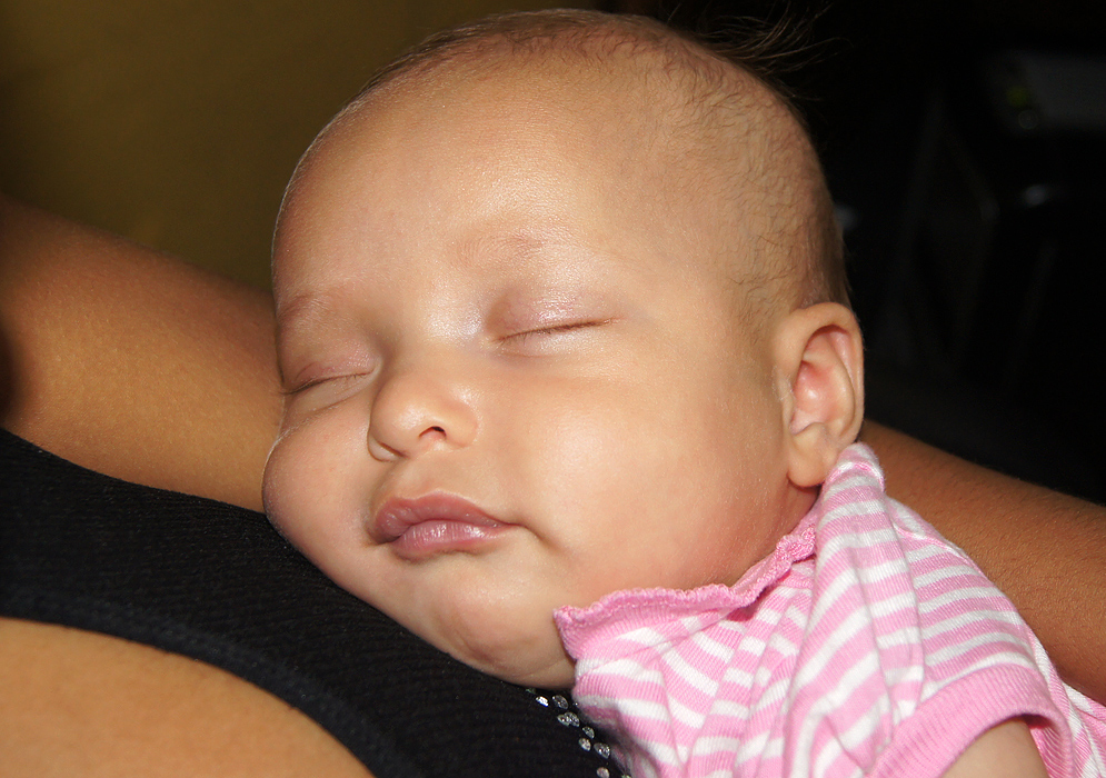 Beautiful American Colombian baby sleeping on top of Colombian mom's chest
