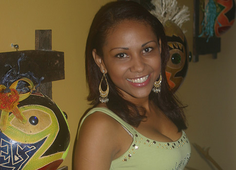 Beautiful Latin woman in front of artisan mask made in Colombia.