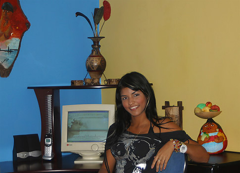 Attractive Colombian woman seated in front of  computer.