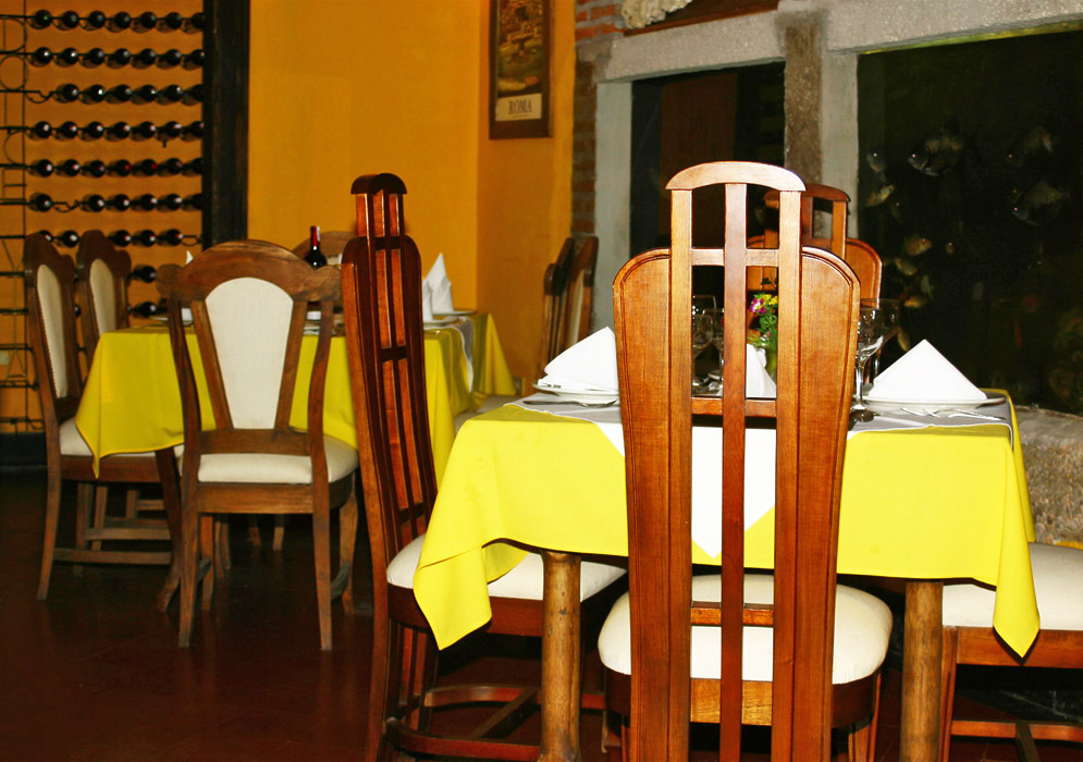 Yellow table cloths and wooden chairs with white cushions