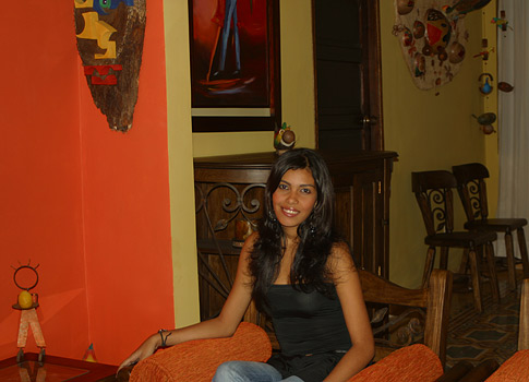 Barranquilla woman standing and modeling the decor of the lodging.