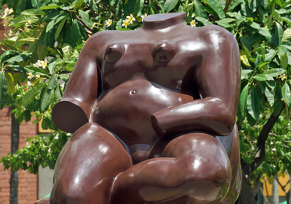 A head and hand-less woman sitting
