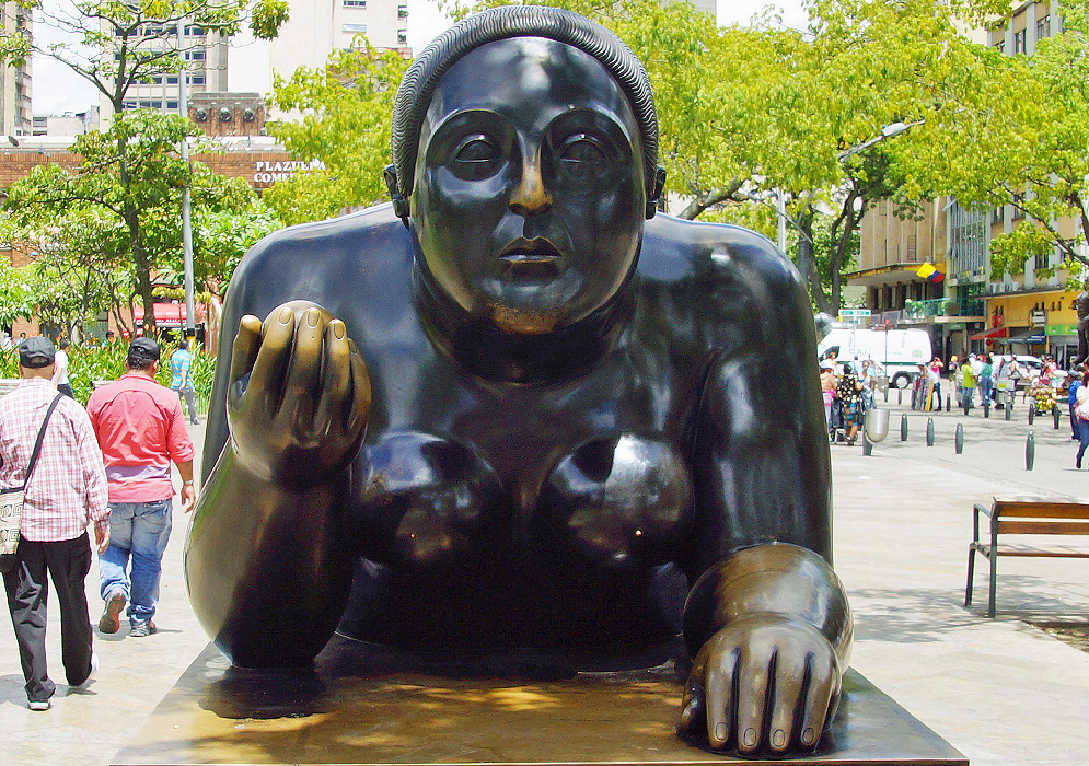 Fat naked woman on her stomach holding a fruit