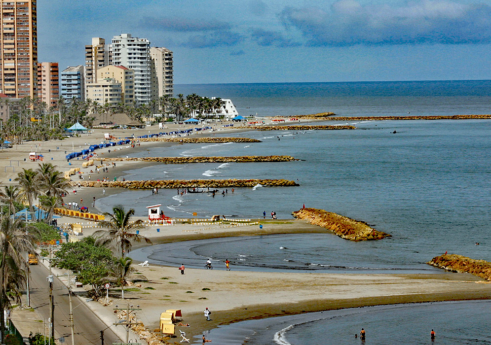 Cartagena beach with wave breaks and skyscraper