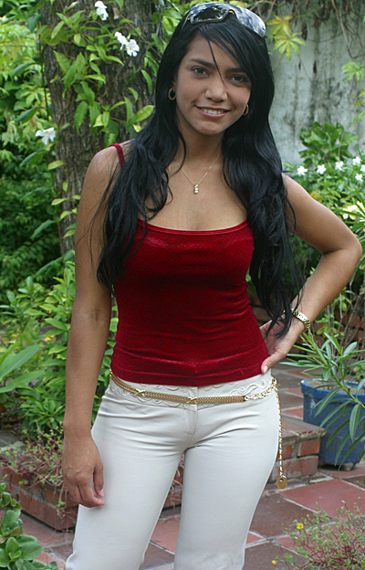 Colombian woman with long black hair standing in patio garden