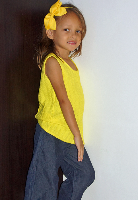 Little girl posing against a wall