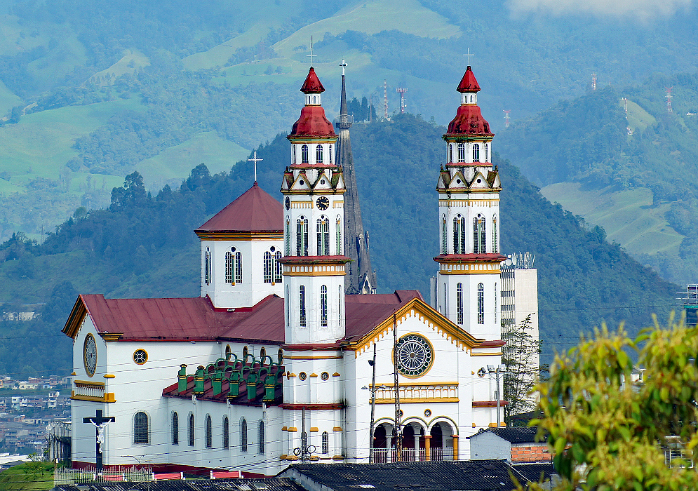 Iglesia de Nuestra Senora Del Rosario A white church with a red roof on top of a hill
