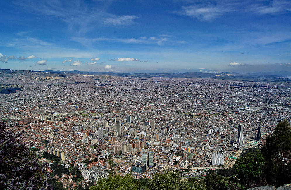 A vista of Bogotá under blue skies with a snow-cap mountain in the background