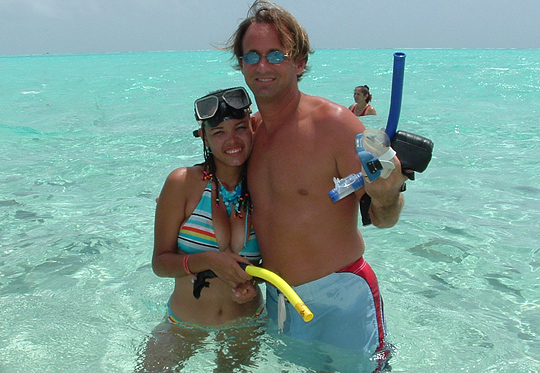 Colombia marriage agency couple standing in the clear blue sea in San Andres Island