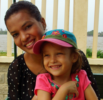 Morena Colobian mom holding on to smiling American daughter