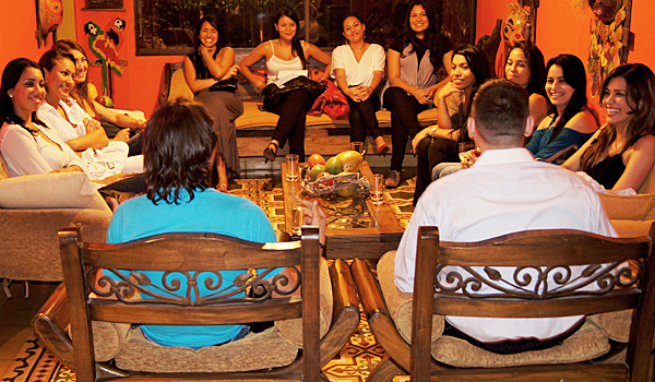 A man and translator seated with a large group of Colombian women during a private romance tour introduction