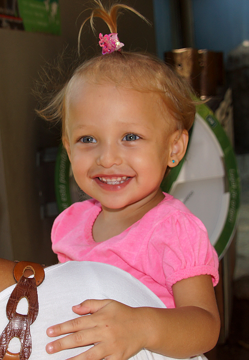 Cute baby wearing a pink top and blue earings