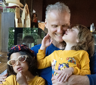 Jamie, father and owner of International Introductions cuddles his two boys Derick Quinn and Dante Colt in yellow shirts during a quiet, tender moment