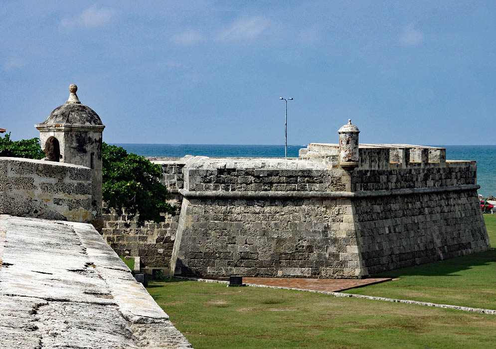 The stone walls and guard-towers of a historical fort overlooking the ocean