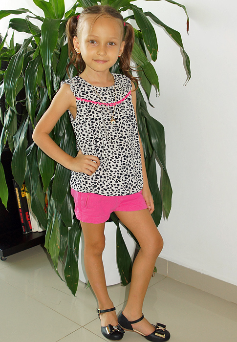 Posing with a black and white spotted shirt and pink shorts
