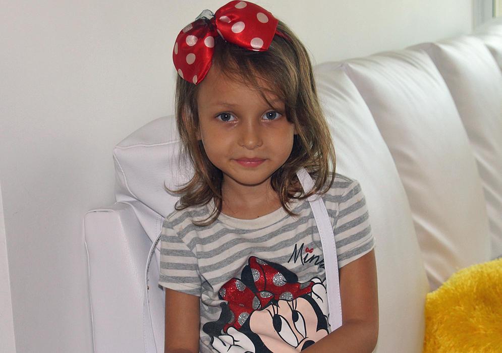 A smirky smile from a gorgeous little girl in her Mini Mouse shirt and bow