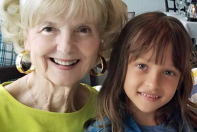 beautiful grandma and granddaughter together side by side smiling