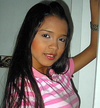 Young Latina Woman in Pink Striped Shirt Attractive young Latina woman with long straight black hair wearing a pink and white striped polo shirt, posing indoors with a confident smile