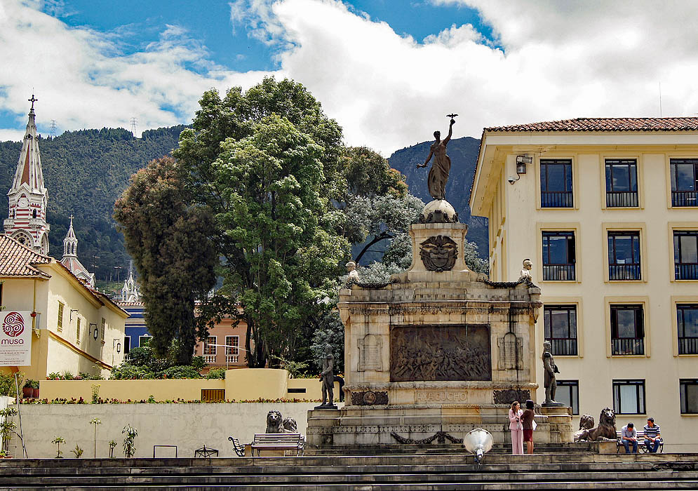 Monumento a la Batalla de Ayacucho A monument to the battle of Ayacucho in the foreground and the top of the Carmen Church in the background
