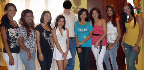 An American man posing with eight pretty Latin women after his romance tour introductions