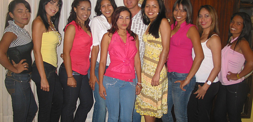 An American man posing with nine attractive Latin women after his romance tour introductions
