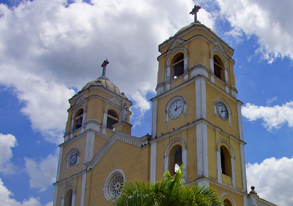 Two church towers with clocks and crosses 