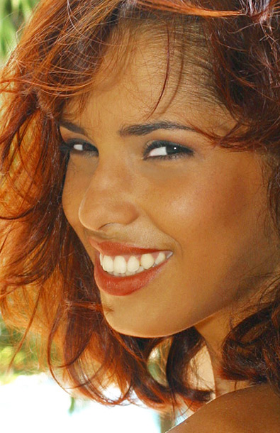 A close-up of a beautiful smiling Latin lady with red hair