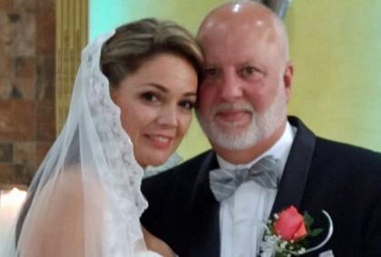 Close-up of a smiling couple posing indoors in front of patterned artwork