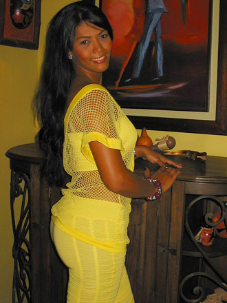 A well-built Colombian woman wearing yellow pants and fishnet shirt