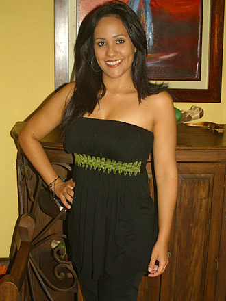 Thirty-five year old Colombian woman wearing a black outfit with a green embroidery