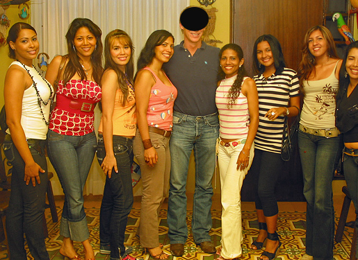 One man posing for a photo in the middle of eight South American women that he was introduced to