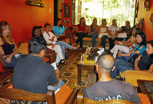 Colombian women meet and talk with two men seated in a bright living room during a marriage agency introduction session