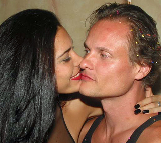 Wife kisses Jamie, the owner of International Introductions on the cheek as he smiles amid party confetti